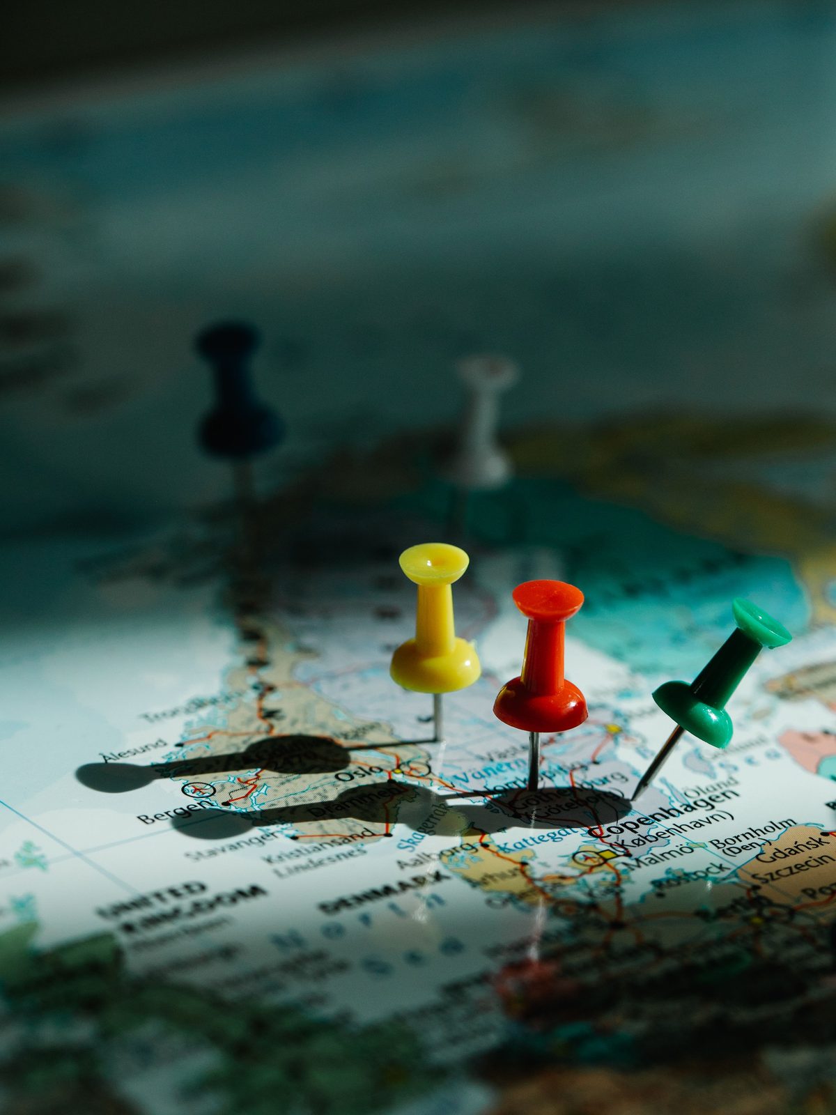 A large world map on an office wall, marked with pins.